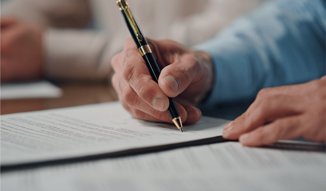 Mano firmando un documento relacionado con herencias, usufructo y fiscalidad