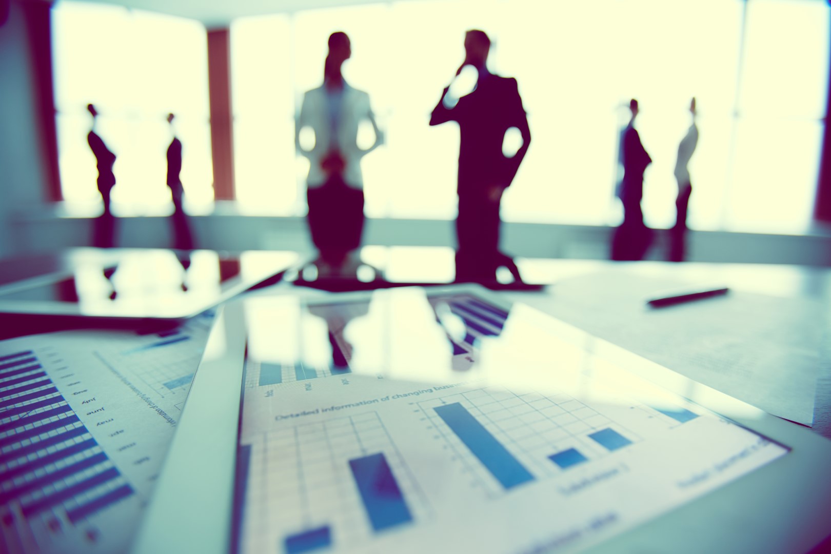 Holding extranjera: cuándo puede ahorrar impuestos y cuándo puede salir caro 4 Ejecutivos revisando documentos financieros en una mesa de trabajo corporativa