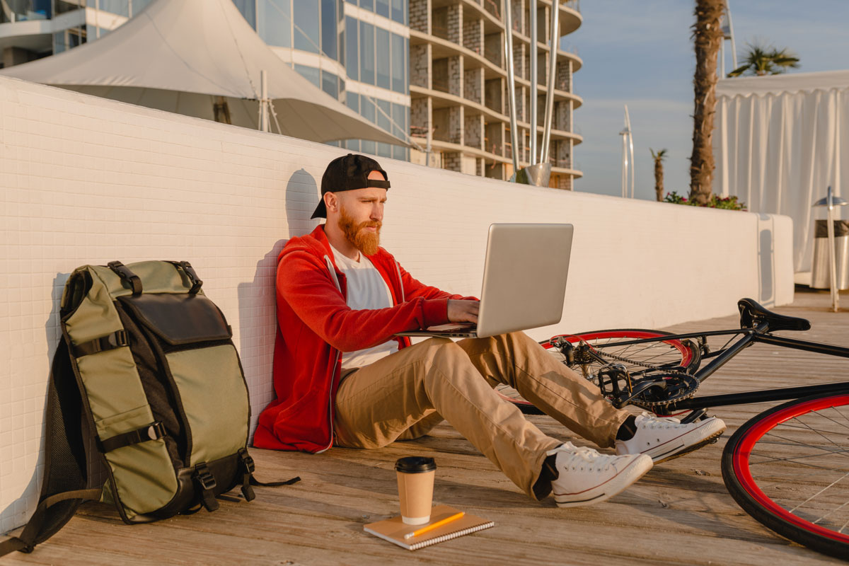 Trasladar la residencia a Dubái desde España: cuándo tiene sentido y cómo hacerlo correctamente 6 Profesional trabajando en remoto con portátil en un entorno urbano, como imagen de apoyo para un artículo sobre trasladar la residencia a Dubái desde España.