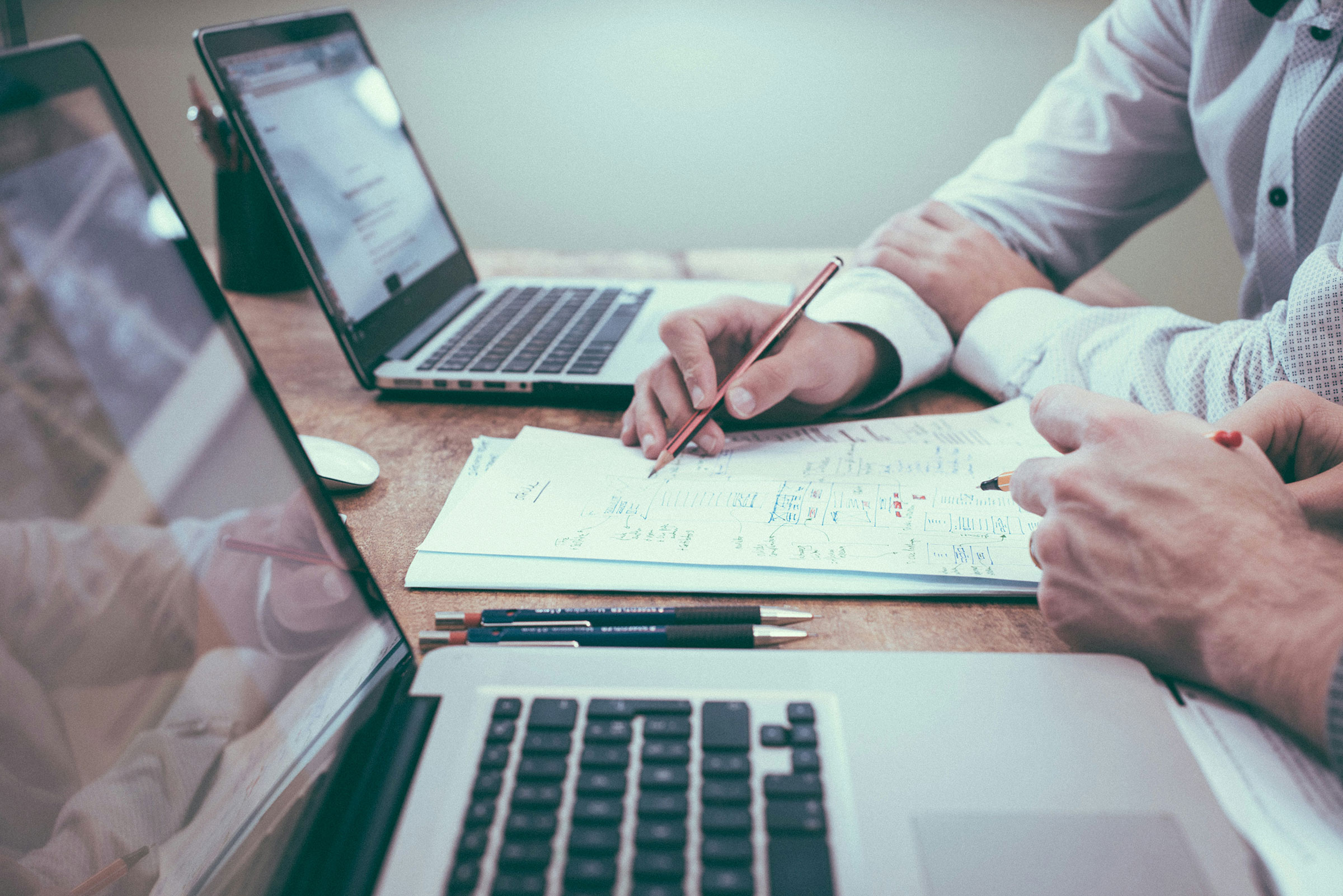 15 Advantages of a Holding Company Structure for Family-Owned Businesses 4 Personas revisando documentación financiera para analizar las ventajas fiscales de una estructura holding.